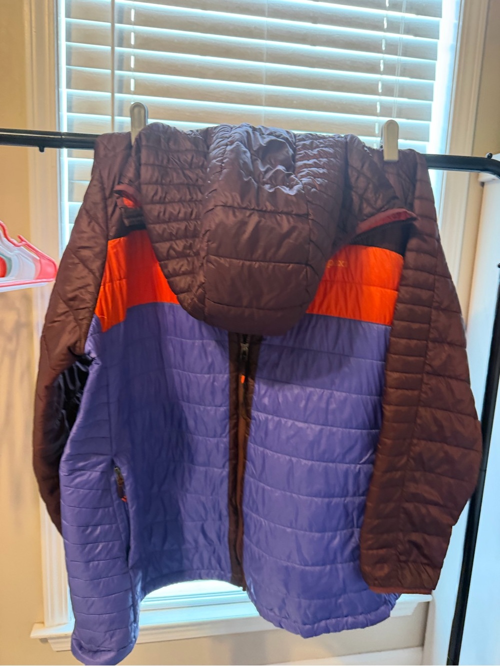 cotopaxi capa Hooded Puffer Jacket in Purple, Orange, and Dark Brown.